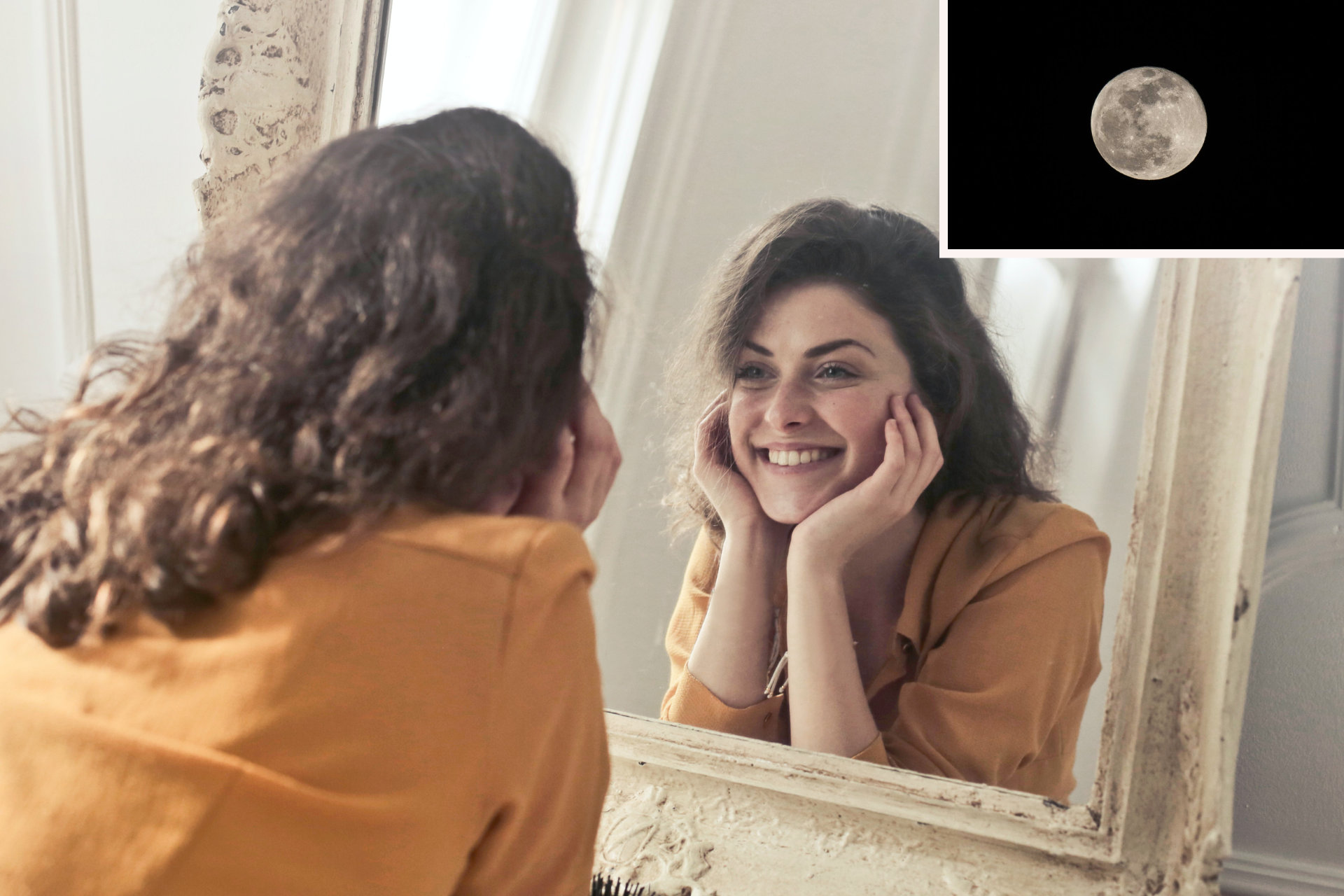 Photo of a person perceived as woman in the left foreground, with dark-brown, long, curly hair and dressed in an orange shirt, back turned towards the viewer; they look into a big old mirror in front of them, so on the right half of the photo, their reflection smiles back at themselves, head propped up on their hands; in the right upper corner a photo of a full moon